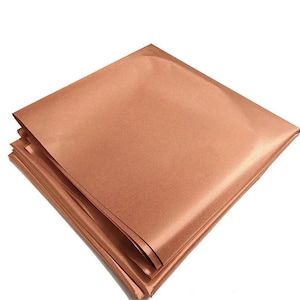 May include: A stack of copper-colored fabric sheets. The fabric has a smooth, satin-like finish.