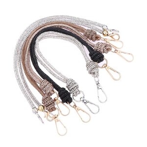 May include: A collection of five flexible bag straps covered in small sparkling rhinestones in silver, rose gold, and black. Each strap features a knotted decorative accent and a metal lobster claw clasp at both ends for secure attachment.