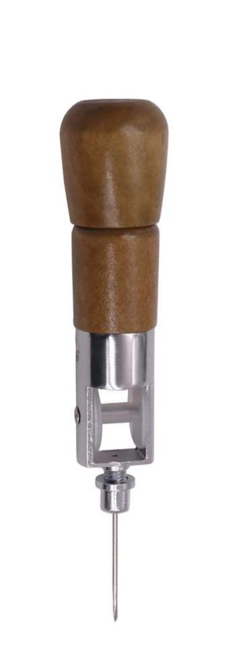 May include: A wooden handled awl with a metal needle. The awl is used for leather crafting and is a tool for making holes in leather.