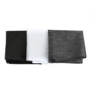 May include: Three rectangular fabric swatches arranged side by side. The left swatch is solid black with a fine texture. The center swatch is solid white and smooth. The right swatch is a heathered dark gray with a visible woven fabric grain.