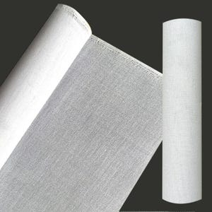 Può includere: Un rotolo di tessuto bianco con una trama visibile. Il materiale è mostrato sia come foglio parzialmente srotolato che mostra la superficie piana, sia come rotolo cilindrico verticale sulla destra, entrambi caratterizzati da una trama uniforme.