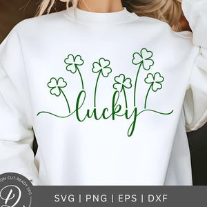 May include: White sweatshirt with a green outline of four-leaf clovers and the word "lucky" in cursive.