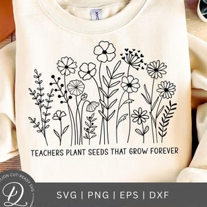 May include: A white sweatshirt with a black line drawing of flowers and the text "TEACHERS PLANT SEEDS THAT GROW FOREVER".
