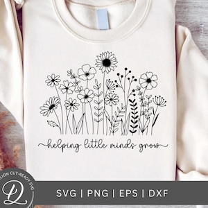 May include: A white sweatshirt with a black outline of a field of flowers and the text "helping little minds grow".