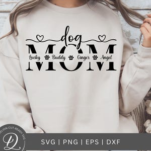 May include: A white sweatshirt with the text "dog mom" in black. The text is surrounded by a heart on each side and a line. Below the text are four paw prints with the names "Lucky", "Buddy", "Ginger", and "Angel" written below each paw print.