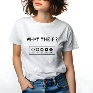 Könnte beinhalten: Weißes T-Shirt mit dem Text "WHAT THE F?" über einer Grafik mit Kamera-Blendeneinstellungen. Die Blendeneinstellungen sind mit f/2.8, f/4, f/5.6, f/11 und f/16 beschriftet. Das T-Shirt hat einen Rundhalsausschnitt.