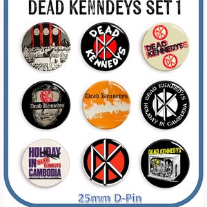 Peut inclure: Ensemble de neuf badges de groupe Dead Kennedys de 25 mm. Les badges présentent divers logos de groupe et pochettes d'album, notamment "Holiday in Cambodia", "Dead Kennedys" et "California über alles".