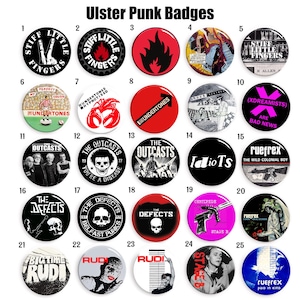 Puede incluir: Una colección de 25 insignias redondas y coloridas de bandas de punk rock. Las insignias presentan nombres de bandas, logotipos y lemas. Algunas de las bandas incluyen Stiff Little Fingers, The Outcasts, The Defects y Rudi.