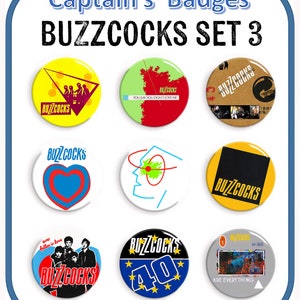 Könnte beinhalten: Satz von acht 25 mm großen Anstecknadeln mit verschiedenen Designs der Band Buzzcocks. Die Designs beinhalten ein Herz, ein Gesicht, ein Bandfoto und Albumcover. Der Text "BUZZCOCKS" erscheint auf jeder Anstecknadel.