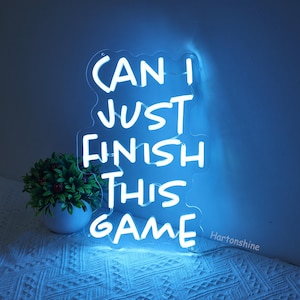 Puede incluir: Un letrero de ne&oacute;n azul con letras blancas que dice "Can I just finish this game".
