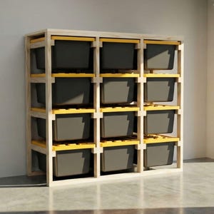 May include: A wooden storage shelf unit with twelve dark gray storage bins. The shelf has a light wood frame with yellow supports. The unit is in a garage with the door open, revealing a green yard.