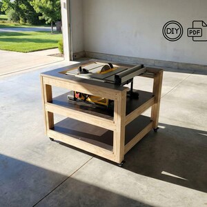 May include: A wooden saw table with a built-in saw, featuring two shelves and wheels for mobility. The table is constructed with light-colored wood and dark-colored shelves. The saw has a yellow blade. The image includes a DIY and PDF icon.