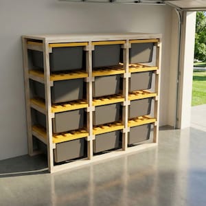 May include: A wooden storage shelf unit with multiple gray bins. The shelf has a light wood frame with yellow supports. The unit is in a garage setting, with the garage door open, revealing a green lawn.