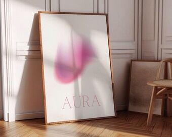 Pode incluir: Uma impressão emoldurada com um design abstrato em tons de rosa e roxo, com a palavra "AURA" em letras rosa.