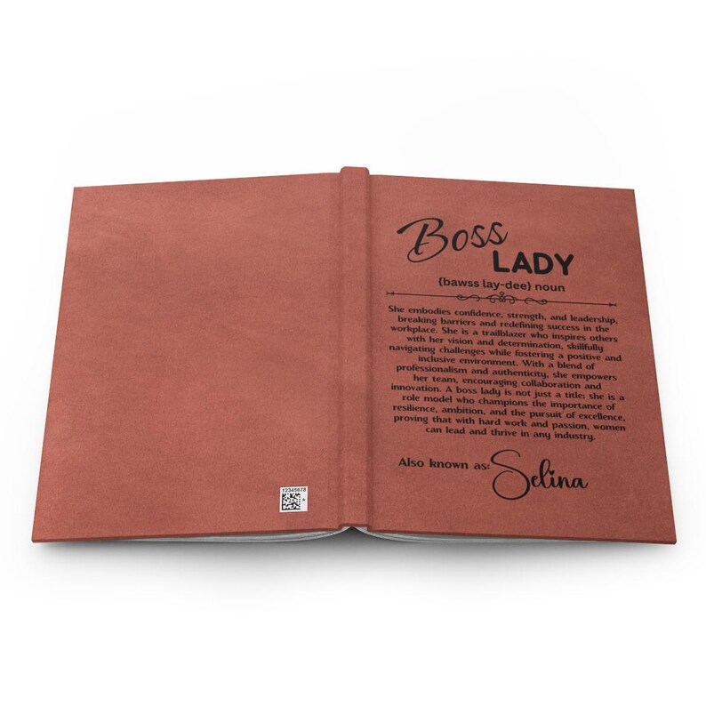 Puede incluir: Diario abierto con una cubierta texturizada de color marr&oacute;n rojizo. El t&iacute;tulo "Boss Lady" est&aacute; escrito en una elegante escritura, con una definici&oacute;n debajo. El texto describe a una mujer que encarna la confianza, la fuerza y el liderazgo. Tambi&eacute;n conocida como Selina.