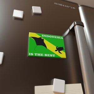 Peut inclure: Un aimant de réfrigérateur vert et jaune avec une silhouette de raie manta et une tortue de mer. L'aimant indique "INDONESIA IS THE BEST".