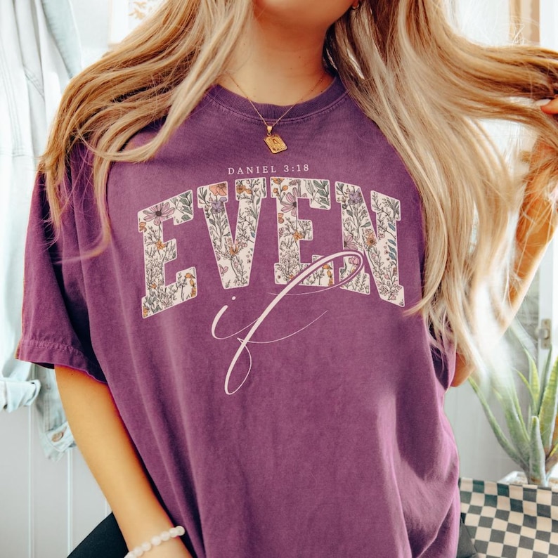 Puede incluir: Camiseta morada con las palabras "EVEN if" en un dise&ntilde;o floral. El texto "DANIEL 3:18" est&aacute; encima de la palabra "EVEN". La camiseta tiene un aspecto vintage y desgastado.