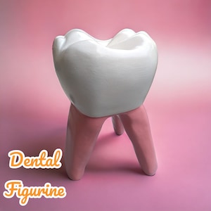 Puede incluir: Una figurita de diente de cerámica blanca con patas rosas. La figurita es un objeto decorativo para una consulta dental o una habitación infantil.