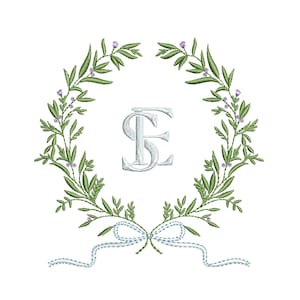 Pode incluir: Um monograma branco com as letras "S" e "E" entrelaçadas, rodeado por uma coroa de folhas verdes e flores roxas. Uma fita azul com um laço está amarrada na parte inferior da coroa.