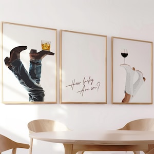 May include: Three framed art prints. One shows denim-clad legs and brown cowboy boots holding a glass of whiskey. The second print has the text "How lucky are we?" The third print shows white boots holding a glass of red wine.