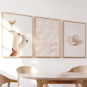 May include: A white ceramic mug with a black handle and the text "But First, Coffee" in a bold, black font. The mug is set against a blurred background. The mug appears to be approximately 10 cm tall.