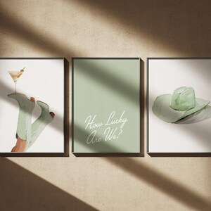 Pu&ograve; includere: Tre stampe incorniciate con uno schema di colori verde. La prima stampa presenta un paio di stivali da cowboy verdi con un bicchiere da martini in cima. La seconda stampa ha uno sfondo verde con il testo "How Lucky Are We?" in bianco. La terza stampa presenta un cappello da cowboy verde.