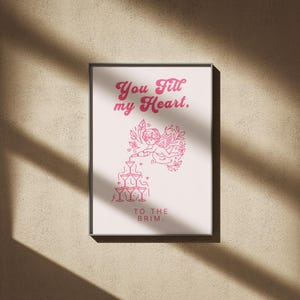 May include: A pink and white print with a heart design and the text "You fill my heart, to the brim."