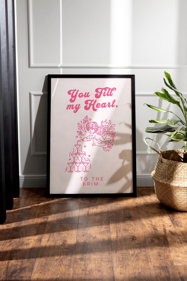 May include: A pink and white poster with a graphic of a cupid pouring a drink into a stack of glasses. The text on the poster reads "You fill my heart, to the brim."
