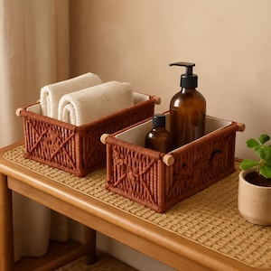May include: Two woven brown storage baskets with white interiors and wooden handles. One basket contains rolled white towels, the other holds brown glass bottles. The baskets are on a light brown woven surface.