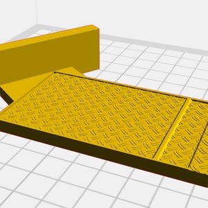 Puede incluir: Una rampa de metal amarilla con una superficie de placa de diamante y una pared vertical corta en un extremo.