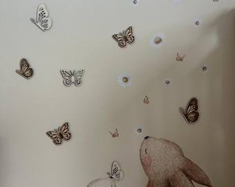 May include: A wall decal scene featuring two brown bunny figures looking up at butterflies and daisies. The butterflies are in various shades of brown and gray. The daisies are white with yellow centers.