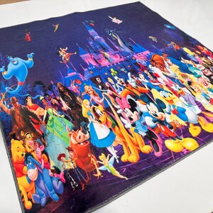 May include: A square, dark purple blanket featuring a vibrant collage of Disney characters. The design includes Cinderella's castle, Genie, Mickey Mouse, and many other beloved characters from various Disney movies. The blanket is likely made of soft fabric.