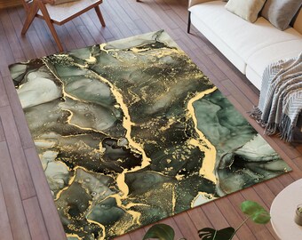 Puede incluir: Una alfombra rectangular con un diseño abstracto. Presenta una mezcla de colores verde oscuro, gris y dorado, creando un efecto marmolado. Los acentos dorados se asemejan a vetas o grietas, agregando interés visual. La alfombra está colocada sobre un suelo de madera, mide aprox. 200 cm x 300 cm.