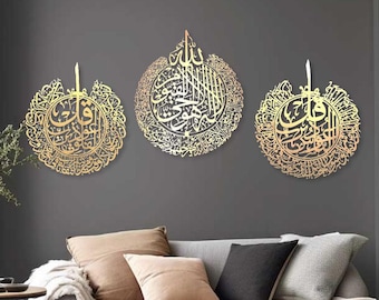 Könnte beinhalten: Drei goldfarbene Wanddekorationen aus Metall mit aufwendiger arabischer Kalligraphie in einem runden Design. Die Stücke sind an einer grauen Wand in einem Wohnzimmer mit einem grauen Sofa und einem Couchtisch angebracht.
