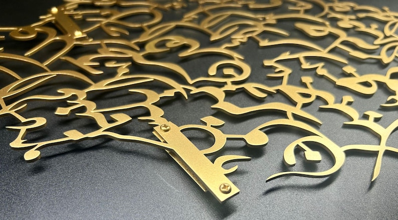 K&ouml;nnte beinhalten: Ein Wandkunstwerk aus goldenem Metall mit einem filigranen, komplizierten Design aus wirbelnden &Auml;sten und Bl&auml;ttern. Das St&uuml;ck ist mit Schrauben an der Wand befestigt.