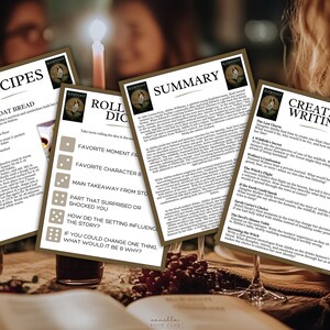 May include: Four printed cards with text on a table, lit by a candle. The cards are labelled "Recipes", "Roll Dice", "Summary", and "Creative Writing". The cards have a brown border and a logo in the top right corner. A glass of wine and a book are in the foreground.