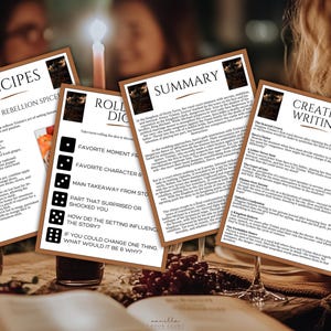 K&ouml;nnte beinhalten: Vier Karten mit Text und Grafiken sind auf einem Tisch angeordnet. Die Karten enthalten Rezepte, eine Zusammenfassung, kreative Schreibaufforderungen und ein W&uuml;rfelspiel. Eine brennende Kerze und Weingl&auml;ser befinden sich im Hintergrund.