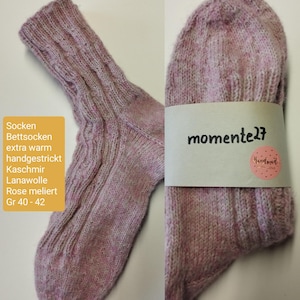 Può includere: Un paio di calzini rosa lavorati a maglia a mano con un motivo a treccia. I calzini sono realizzati con una miscela di cashmere e lana. L'etichetta riporta "Socken Bettsocken extra warm handgestrickt Kaschmir Lanawolle Rose meliert Gr 40-42" e "momente27 Handmade with love".