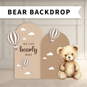 May include: A brown and beige backdrop with a teddy bear, hot air balloons, and the text "We can bearly wait".