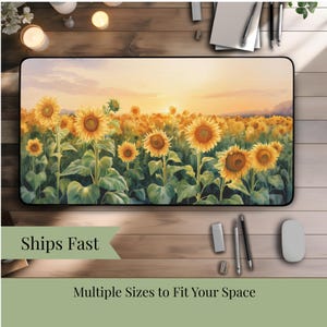 Op de afbeelding: Rechthoekige bureaumat met een aquarel schilderij van een zonnebloemveld bij zonsondergang. De mat heeft een zwarte rand en de afbeelding toont gele zonnebloemen met groene bladeren. De tekst "Multiple Sizes to Fit Your Space" staat onderaan.