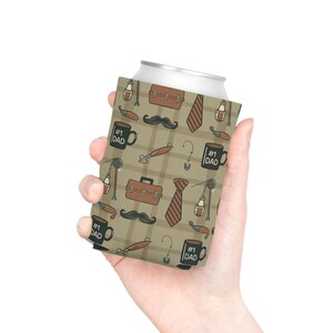 May include: A can cooler with a repeating pattern of brown briefcases, ties, fishing lures, mustaches, and coffee mugs with the text "#1 DAD" on a tan plaid background. The cooler is held by a person.