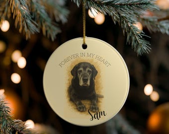 May include: A round, cream-colored Christmas ornament with a watercolor-style image of a black Labrador Retriever. The text "FOREVER IN MY HEART" is arched above the dog, with the name "Sam" in script below.