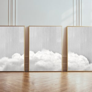 May include: Three framed abstract art prints with a white cloud design on a gray background.