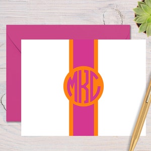 May include: White stationery card with a pink and orange vertical stripe design. The stripe has a circle with the monogram "MKC" in pink letters.