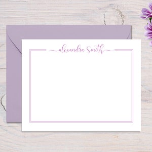 May include: A white stationery card with a purple border and the name "alexandra Smith" written in cursive script.
