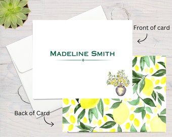 May include: White card with green text that reads "MADELINE SMITH" and a small watercolor illustration of a potted lemon tree. The back of the card features a repeating pattern of watercolor lemons and leaves on a white background.