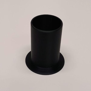 May include: A black cylindrical object with a wide, flat base. The object is a solid black color and has a smooth, matte finish. The cylindrical portion is approximately 4 inches tall and 2 inches in diameter.