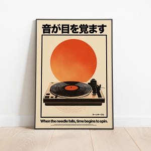 Pode incluir: Um cartaz retangular com um gráfico de um gira-discos preto centrado sob um grande círculo laranja. O texto diz "音が目を覚ます" no topo, "ターンテーブル" no canto inferior direito e "When the needle falls, time begins to spin." na parte inferior.