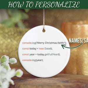 May include: A white ceramic Christmas ornament with a gold string for hanging. The ornament has the text "HOW TO PERSONALIZE" at the top and a code snippet with the text "Merry Christmas Keith!" and "NAMES/SAYING". A lit candle is in the background.