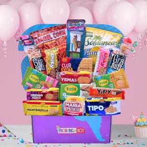 May include: A purple box filled with various snacks, including chips, cookies, and candies. The box has a blue and white design and the text "PACHANGA BOX". Pink balloons are in the background.